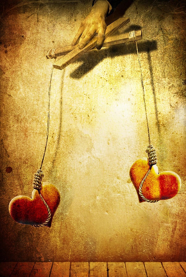 Two red hearts hanging by strings, manipulated by a hand like marionettes, symbolizing control and emotional manipulation in relationships.